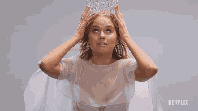 a woman in a white dress is holding a crown on her head with a netflix logo in the corner