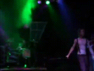 a man is standing on a stage with a microphone in his hand