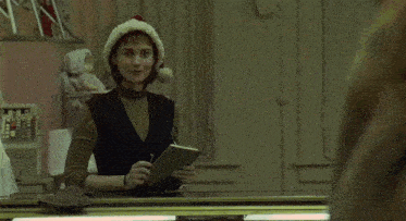a woman wearing a santa hat is looking at herself