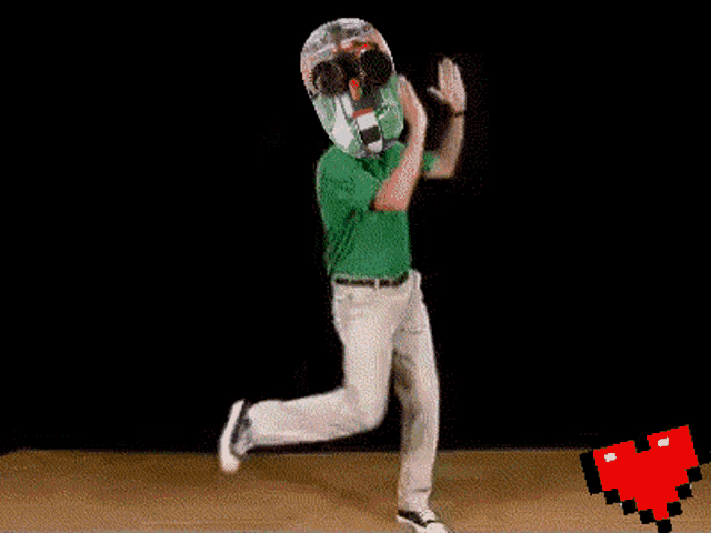 a man in a green shirt and white pants is dancing