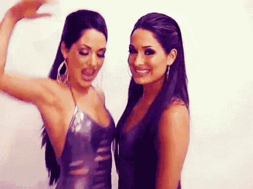 two beautiful women are standing next to each other and smiling .