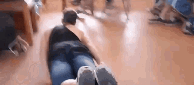 a woman is laying on the floor with her legs crossed while a group of people are standing around her .