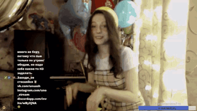 a woman in a plaid dress stands in front of balloons in a room