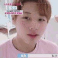 a close up of a young man 's face in a pink shirt .