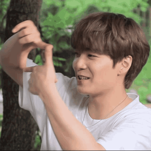 a young man making a heart shape with his fingers