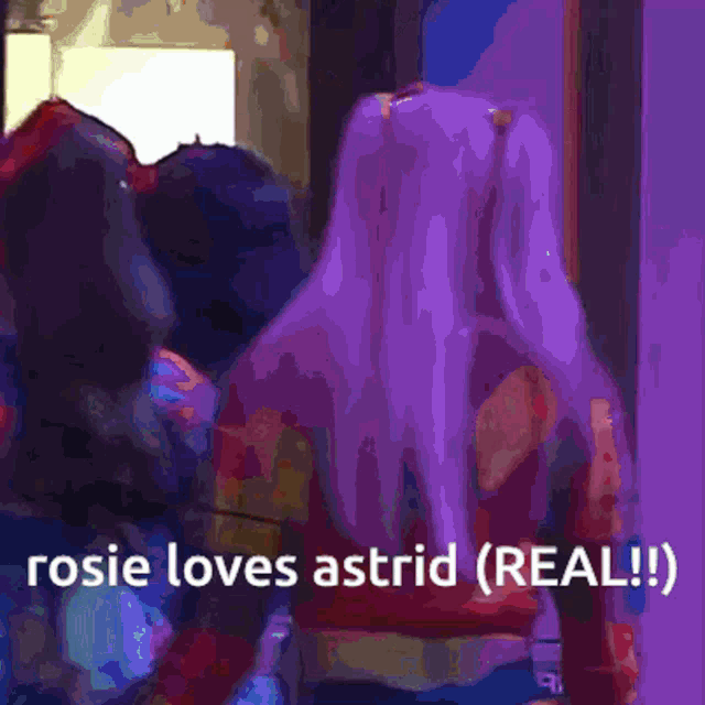 a woman with purple hair is standing in front of a mirror with the caption rosie loves astrid ( real )