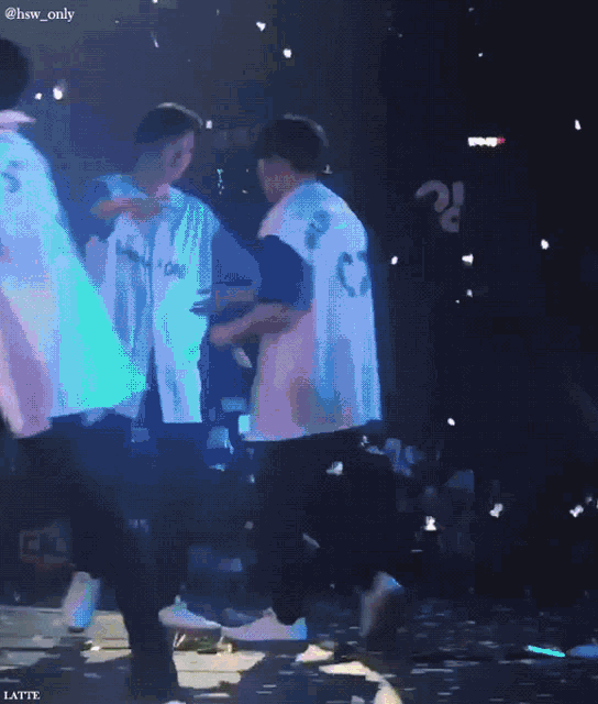a couple of people hugging on a stage with the words latte on the bottom right