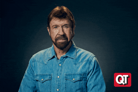 a man in a denim shirt is standing in front of a qt sign