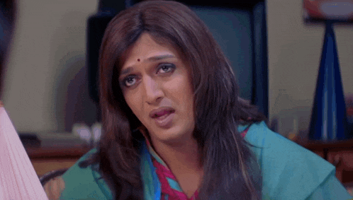 a woman in a wig looks at the camera with a serious look on her face