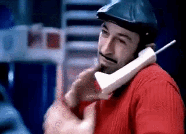 a man wearing a helmet is talking on a cell phone