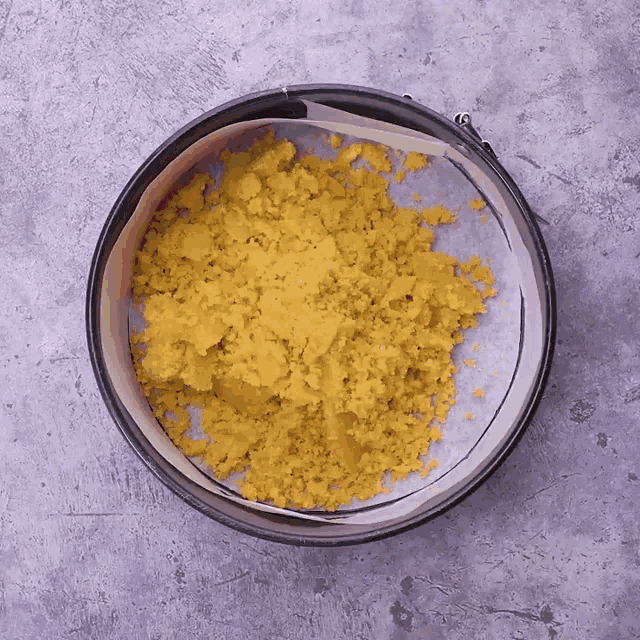 a round pan filled with yellow powder on a table
