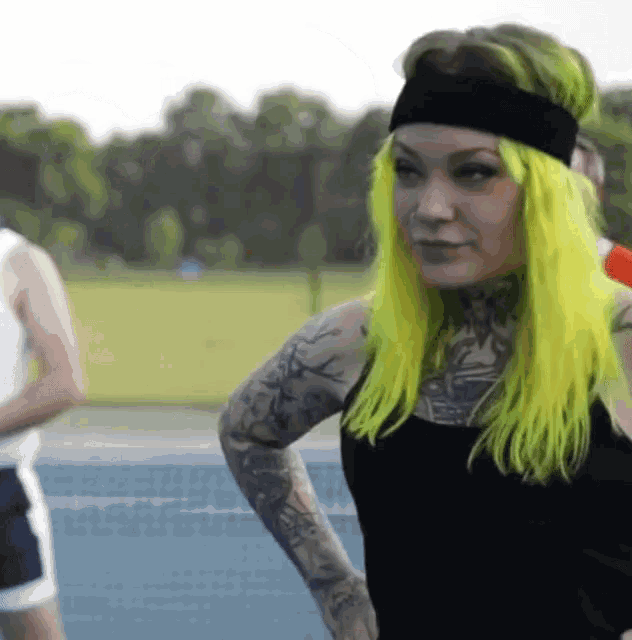 a woman with neon green hair wearing a headband