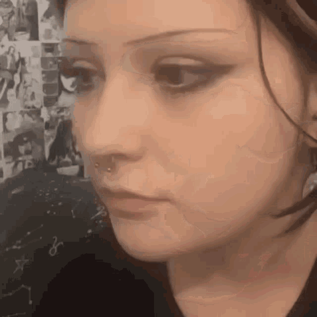 a close up of a woman 's face with a piercing in her nose