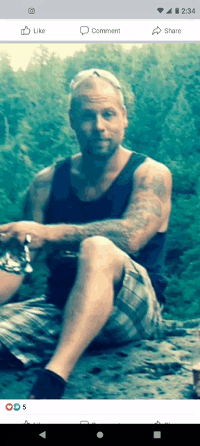 a man is sitting on a rock with his legs crossed in a facebook photo