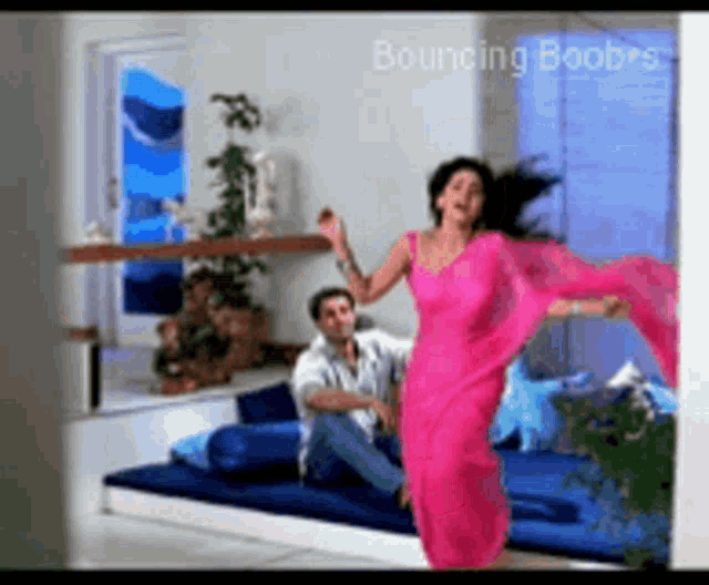 a woman in a pink saree is dancing with a man in a white shirt
