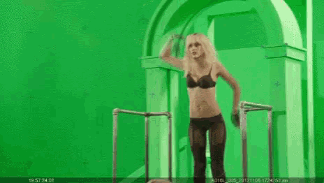 a group of people are standing around a green screen .