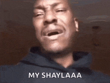 a man in a hoodie is crying with his mouth open and the words `` my shaylaa '' written on his face .