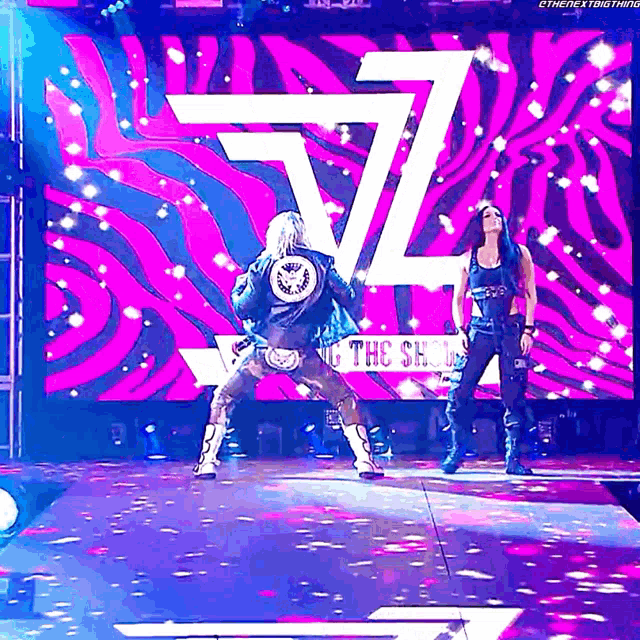 two women are standing in front of a large screen that says ethenextbig thing