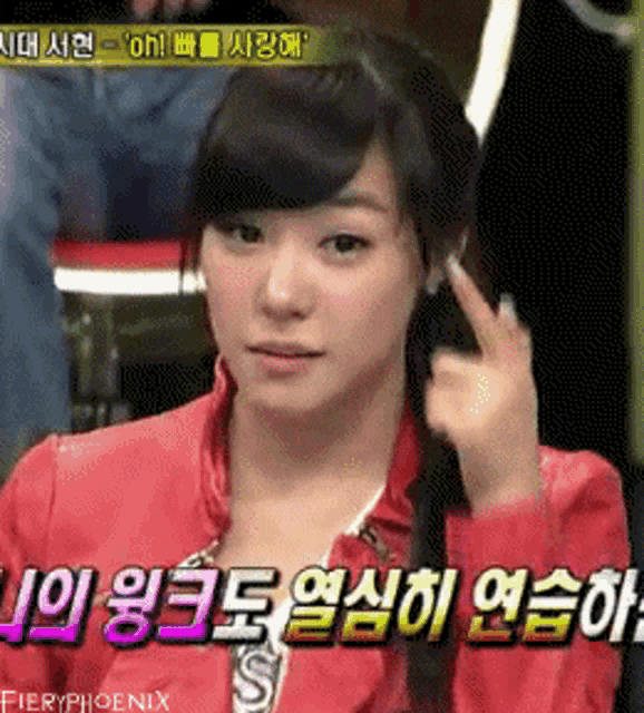 a girl in a red jacket is giving a thumbs up sign