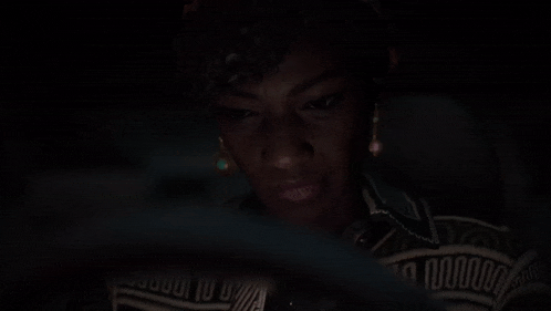a close up of a woman 's face in a dark room looking at the camera .