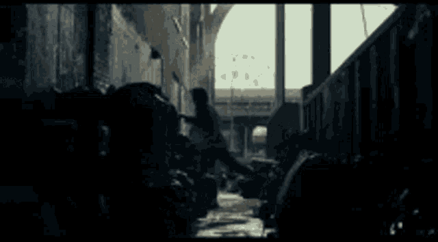 a dark alleyway with a bridge in the distance