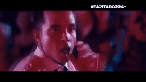 a group of people are dancing in a dark room with the words tapitaborra on the bottom .