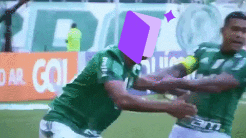 two soccer players are hugging each other in front of a sign that says dar gol