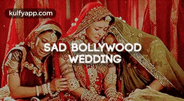 a bride and groom are sitting next to each other on a bed in a sad bollywood wedding .