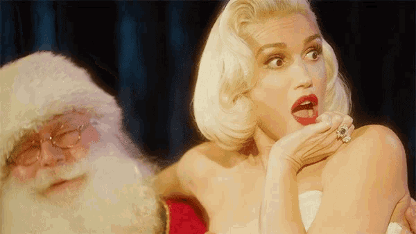 a woman with a ring on her finger is standing next to santa claus