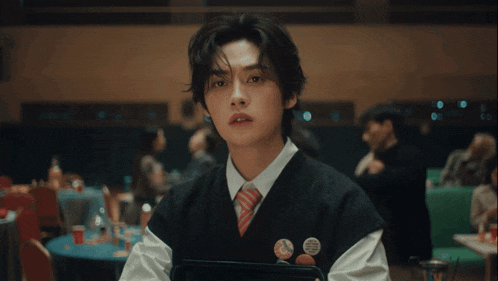 a young man in a suit and tie is making a face