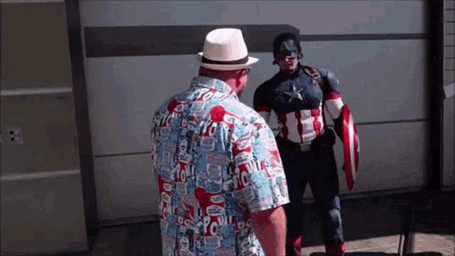 a man in a captain america costume stands next to another man