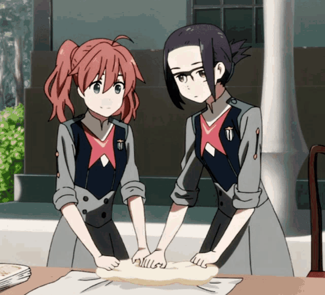 two anime girls are kneading dough together