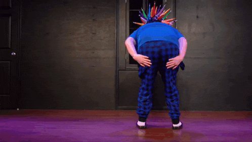 a person wearing a blue shirt and blue plaid pants has a bunch of colored pencils on their head