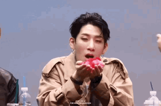 a young man in a trench coat is holding something in his hands and the words just on u are on the bottom