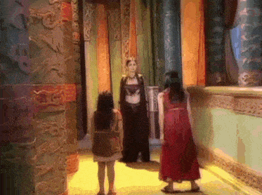 a woman in a red dress is standing next to a woman in a black robe .