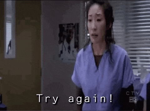 a woman in purple scrubs is standing in a hospital room and says `` try again ! ''