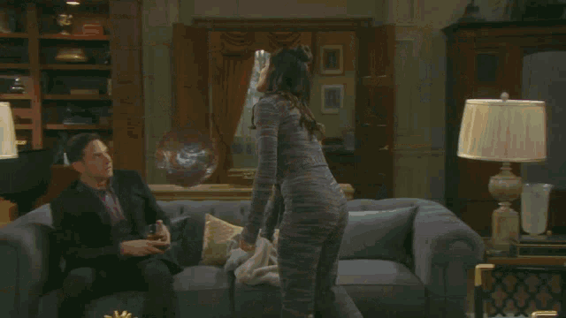 a man and a woman are sitting on a couch talking