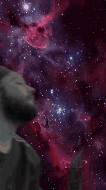 a man with his eyes closed looks up at a colorful sky