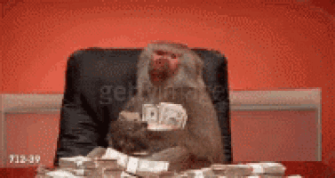 a monkey is sitting at a desk with a pile of money