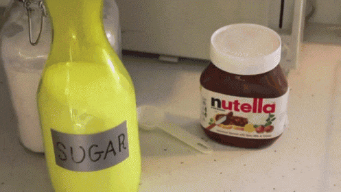 a bottle of sugar and a jar of nutella on a counter