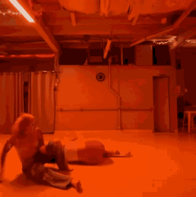 a person laying on the floor in a room with a target on the wall