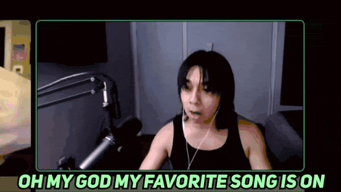 a woman sitting in front of a microphone with the words " oh my god my favorite song is on " above her