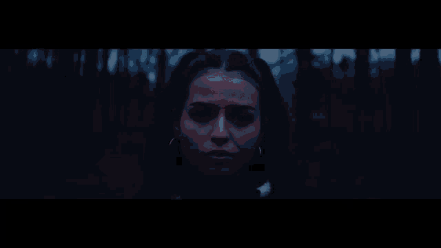 a close up of a woman 's face with red lights shining on her face