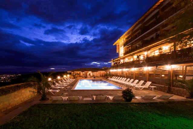 a large building with a swimming pool in front of it at night