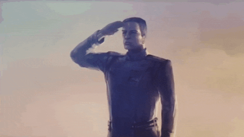 a man with a robotic arm is standing in a field .