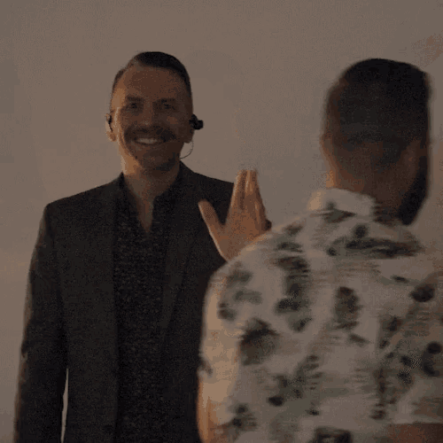a man in a suit is smiling with his arms outstretched
