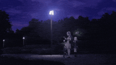 a group of people are standing under a street light