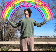 a man in a green sweater stands in front of a rainbow that says big ass