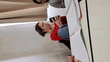 a woman sitting at a table with a cell phone