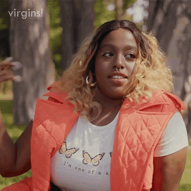 a woman wearing an orange vest and a t-shirt that says i 'm one of a k .
